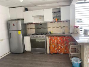 a kitchen with a stove and a refrigerator at CÓMODA HABITACIÓN CENTRAL in Machala