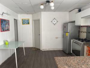 a kitchen with a glass table and a refrigerator at CÓMODA HABITACIÓN CENTRAL in Machala +4 photos