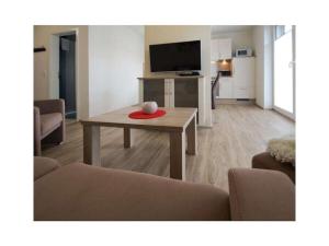 a living room with a table and a tv at Holiday apartment Ankerstek in Norddeich