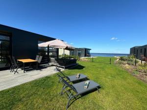 patio con tavolo e sedie sull'erba di Chalet in Enkhuizen with Swimming Pool a Enkhuizen