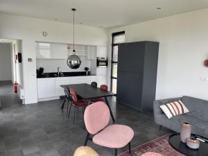una cucina e un soggiorno con tavolo e sedie di Chalet in Enkhuizen with Swimming Pool a Enkhuizen