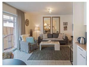 a living room with a couch and a table at Holiday Apartment Dünenrose in Norddeich