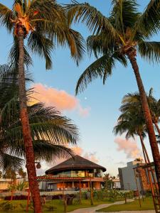 two palm trees in front of a building at Naluum Milagres in Passo de Camarajibe +30 photos