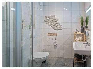 a bathroom with a toilet and a sink at Holiday Apartment Dünenrose in Norddeich