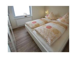 a bedroom with two beds with pillows and a window at Holiday apartment Ankerstek in Norddeich