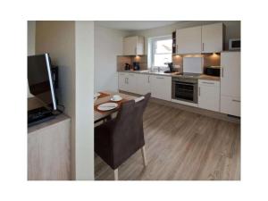 a kitchen with a table and a dining room at Holiday apartment Ankerstek in Norddeich