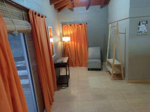 a room with orange curtains and a chair and a table at Casa de campo en Yala, Jujuy in Yala