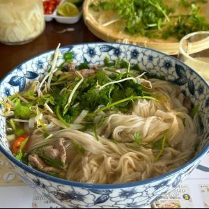 una ciotola blu e bianca piena di noodles e verdure di MOJO Boutique HOTEL a Phu Quoc