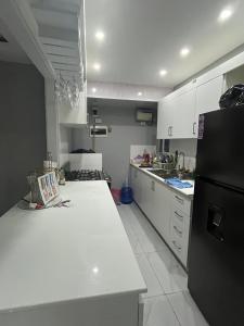 cocina con encimera blanca y nevera negra en Sol tropical, en La Grúa