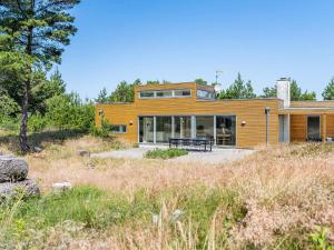 a large wooden house in the middle of a field at 6 person holiday home in Henne in Henne Strand