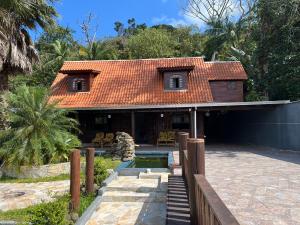 a house with an orange tiled roof and a staircase at Recanto da Natureza in Matinhos