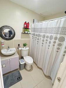 ein Badezimmer mit Toilette und Duschvorhang in der Unterkunft Betty's Midori in Antipolo + 32 Fotos