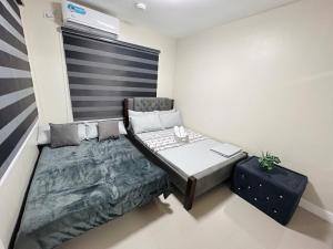 ein kleines Zimmer mit einem Bett und einem Tisch in der Unterkunft Betty's Midori in Antipolo