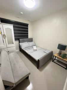 ein kleines Schlafzimmer mit einem Bett und einer Couch in der Unterkunft Betty's Midori in Antipolo
