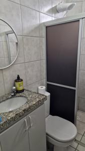 a bathroom with a toilet and a sink and a mirror at Apartamento da Tia Jaci in Paulista