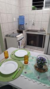 a kitchen counter with two plates on a table at Apartamento da Tia Jaci in Paulista