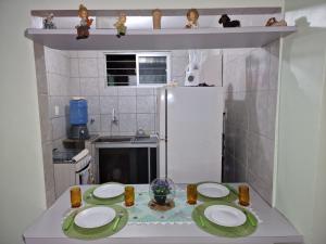 a small kitchen with two plates and a refrigerator at Apartamento da Tia Jaci in Paulista +5 photos