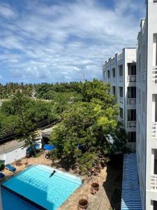 einen Blick über einen Pool neben einem Gebäude in der Unterkunft Sunrise Resort Apartments in Mombasa