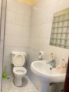 ein weißes Badezimmer mit Toilette und Waschbecken in der Unterkunft Sunrise Resort Apartments in Mombasa