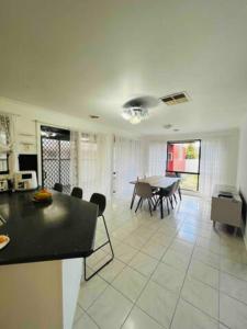 a living room with a table and a dining room at A spacious Vacation Home nearby Melbourne Airport in Caroline Springs