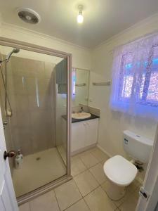 a bathroom with a shower and a toilet and a sink at A spacious Vacation Home nearby Melbourne Airport in Caroline Springs