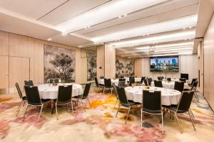 a conference room with tables and chairs and a projection screen at Pan Pacific Perth in Perth +51 photos