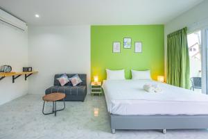 a bedroom with a large white bed and a chair at Karon Hotel at 22 in Karon Beach