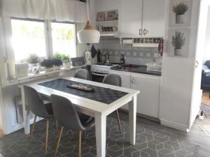 4 star holiday home in BORÅS في بوراس: مطبخ ابيض وفيه طاوله وكراسي