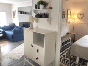 4 star holiday home in BORÅS في بوراس: خزانة بيضاء في غرفة المعيشة مع أريكة زرقاء