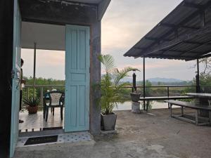 an open door of a house with a table and chairs at A small house next to the canal in Prachuap Khiri Khan