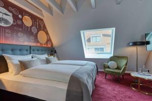 a bedroom with a large bed and a chair at Boutique by EMPA in Ulm