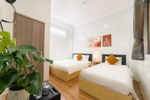 ホーチミン・シティにあるThiên Quốc Hotelのベッドルーム1室(ベッド2台、鉢植え付) +53枚の写真
