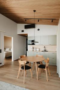 a kitchen and dining room with a wooden table and chairs at Strandis Smokehouse Camping & Resort, Villas in Luoto