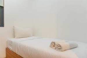 łóżko z białą pościelą i ręcznikami w obiekcie Serene and Modern 2BR Sky House BSD Apartment near AEON By Travelio w mieście Tangerang +15 zdjęć