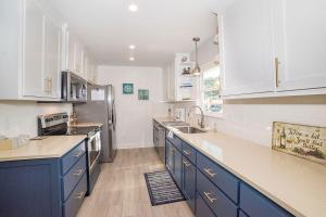 a kitchen with blue cabinets and white appliances at Anchorage Haus in Fredericksburg