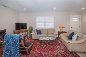 a living room with two couches and a tv at Anchorage Haus in Fredericksburg