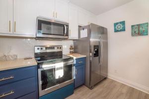 a kitchen with blue cabinets and a stainless steel refrigerator at Anchorage Haus in Fredericksburg +11 photos