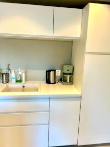 a kitchen with white cabinets and a sink at Havn i Etne with fjordview in Etnesjøen