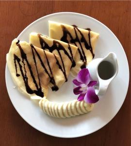 a white plate with three desserts and a banana at Tam Coc Cozy Homestay in Ninh Binh