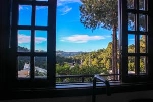a window with a view of a mountain view at Recanto do Bosque in Campos do Jordão