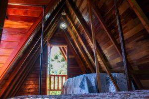 a bedroom in a tree house with a window at Recanto do Bosque in Campos do Jordão