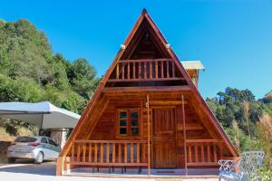 a small log cabin with a roof at Recanto do Bosque in Campos do Jordão +55 photos