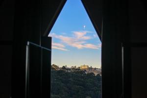 a view from a window of a hill with a building at Recanto do Bosque in Campos do Jordão