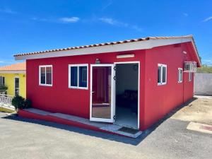 a red house with an open door in a parking lot at Guest Favorite - Central - Gated - 2 Bedrooms in Willemstad