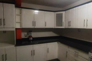 a kitchen with white cabinets and black counter tops at Comodidad y Confort en Morelia in Morelia