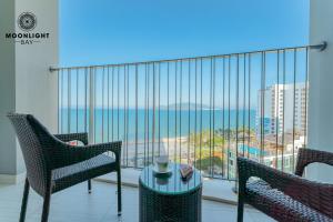 a balcony with chairs and a table and a view of the ocean at Nha Trang Superview Holidays in Nha Trang