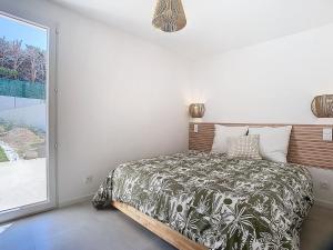 a bedroom with a bed and a large window at Le Romarin Bas de villa T2 avec jardin et parking au pied de la Forêt in La Penne-sur-Huveaune