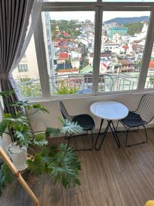 a room with a table and chairs and a large window at 1 House 1 in Da Lat
