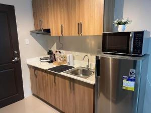 a kitchen with a microwave on top of a refrigerator at Crosswinds Tagaytay Holiday Home by KTCH in Tagaytay +32 photos