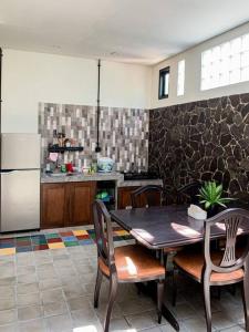 una cucina con tavolo, sedie e frigorifero di SakaLoka Wirokerten Homestay a Gondowulung